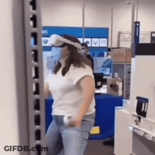 A Woman Wearing A Virtual Reality Headset Is Standing In A Store GIF