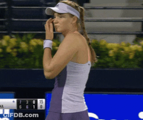 A Woman Wearing A Visor Is Standing In Front Of A Scoreboard That Shows The Score Of 7 To 15 GIF