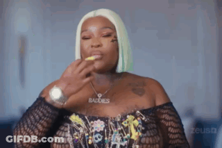 A Woman Wearing A Watch And A Necklace With The Word Baddies On It . GIF