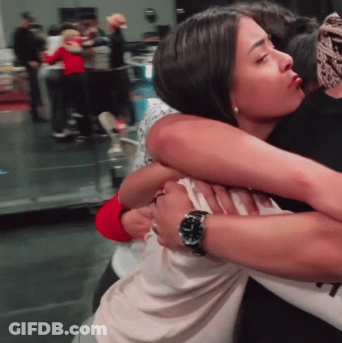 A Woman Wearing A Watch Is Hugging A Man GIF