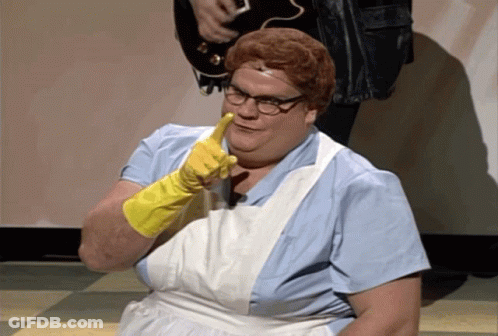 A Woman Wearing A White Apron And Yellow Gloves Is Pointing At The Camera GIF