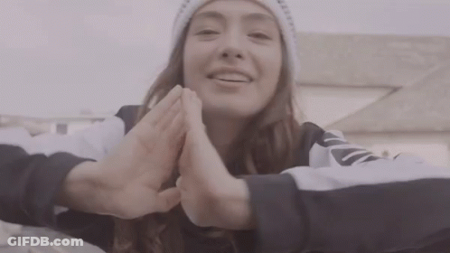 A Woman Wearing A White Beanie And A Black And White Sweatshirt With The Word Nike On The Sleeve GIF
