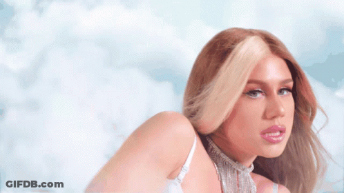 A Woman Wearing A White Bra And A Choker Looks At The Camera GIF