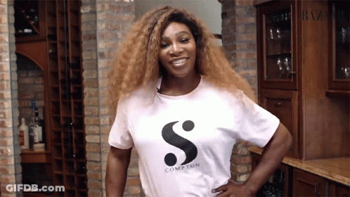 A Woman Wearing A White Compton T-Shirt Smiles GIF
