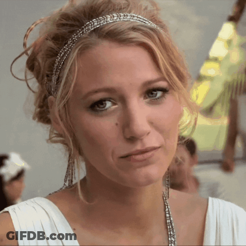 A Woman Wearing A White Dress And A Headband Looks At The Camera GIF