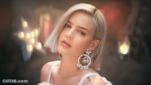 A Woman Wearing A White Dress And Earrings Has A Tattoo On Her Arm That Says ' I Love You ' GIF