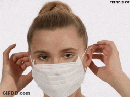 A Woman Wearing A White Face Mask With The Word Trendizisst Behind Her GIF