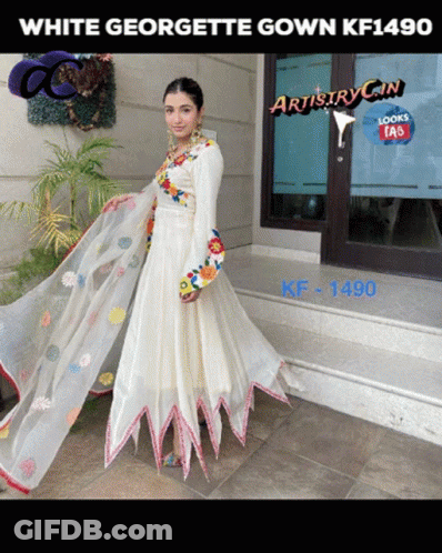 A Woman Wearing A White Georgette Gown Kf1490 Stands In Front Of A Building GIF