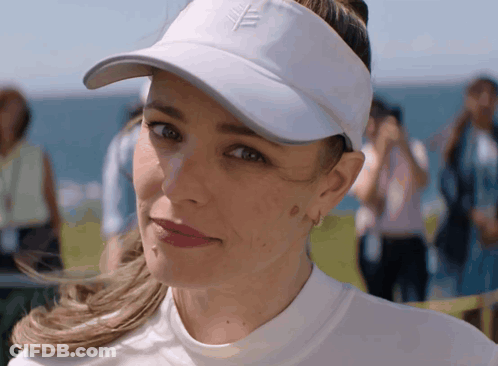A Woman Wearing A White Hat And Visor With A Leaf On It GIF