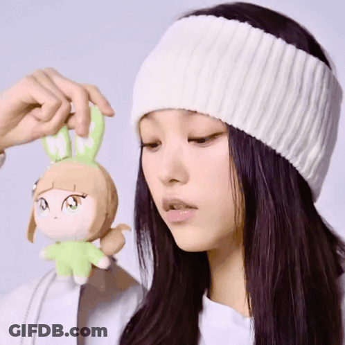A Woman Wearing A White Hat Is Holding A Stuffed Animal With A Bunny Head GIF