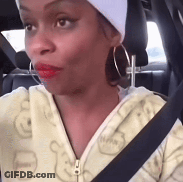 A Woman Wearing A White Headband And Hoop Earrings Is Sitting In The Back Seat Of A Car GIF