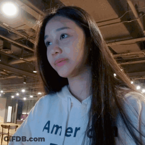 A Woman Wearing A White Hoodie That Says " America " GIF