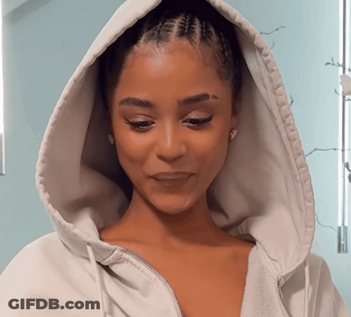 A Woman Wearing A White Hoodie With A Zipper On The Front GIF