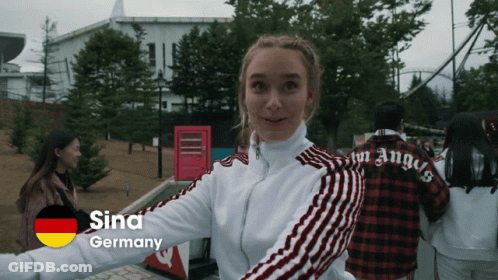A Woman Wearing A White Jacket With Red Stripes And The Word Sina Germany On The Bottom GIF