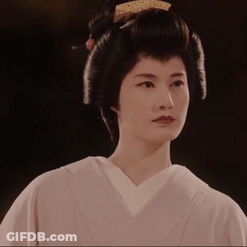 A Woman Wearing A White Kimono And A Black Hairdo GIF