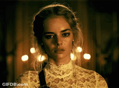 A Woman Wearing A White Lace Top Has A Tear Running Down Her Face GIF