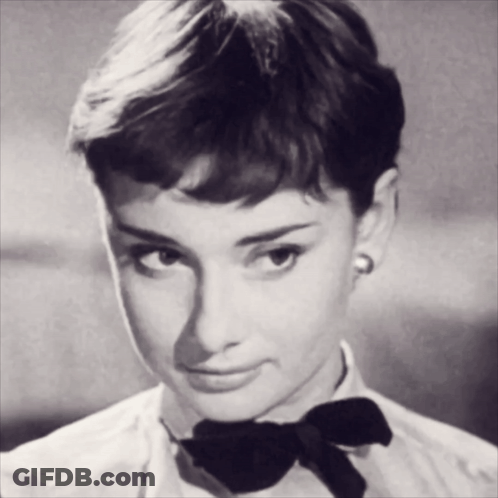 A Woman Wearing A White Shirt And A Black Bow Tie GIF