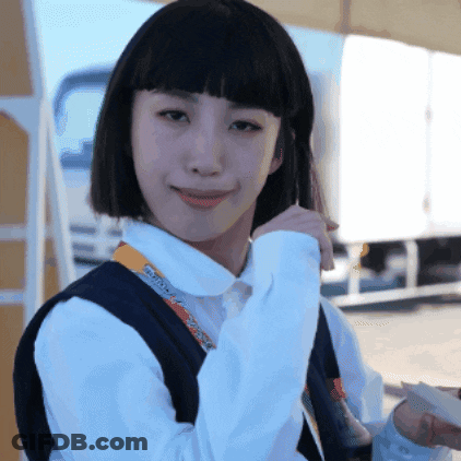 A Woman Wearing A White Shirt And A Black Vest Has A Lanyard Around Her Neck That Says ' Tokyo ' GIF