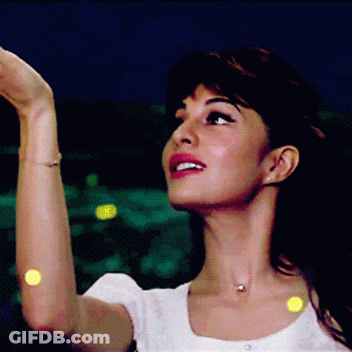A Woman Wearing A White Shirt And A Necklace Looks Up At The Sky GIF