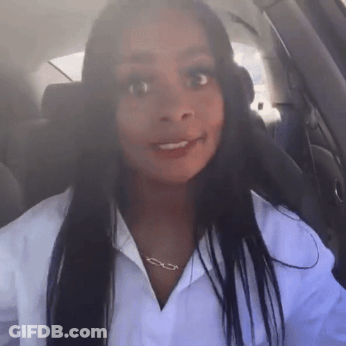 A Woman Wearing A White Shirt And A Necklace With The Letter E On It GIF