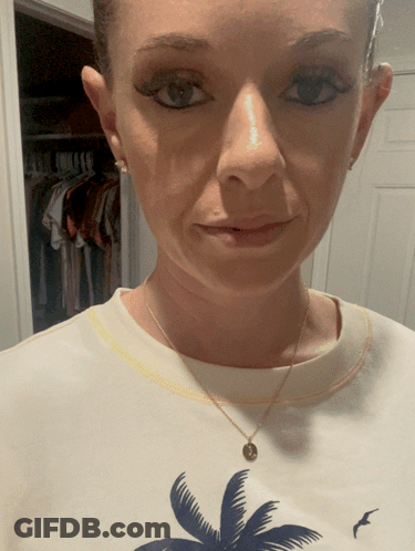 A Woman Wearing A White Shirt With A Palm Tree And A Bird On It GIF