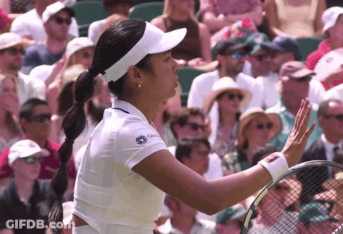 A Woman Wearing A White Shirt With The Word Global On It Holds A Tennis Racquet GIF