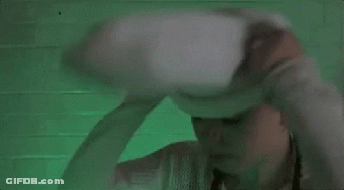 A Woman Wearing A White Sweater And A White Hat With A Face On It . GIF