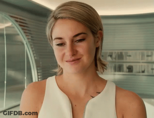 A Woman Wearing A White Tank Top Has A Tattoo On Her Shoulder GIF