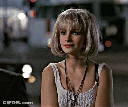 A Woman Wearing A White Tank Top With A Necklace Around Her Neck GIF