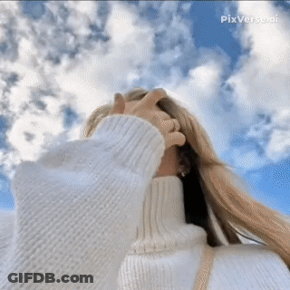 A Woman Wearing A White Turtleneck Sweater Is Looking Up At The Sky GIF