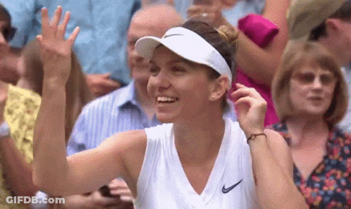 A Woman Wearing A White Visor And A White Tank Top Is Smiling And Waving At The Crowd . GIF
