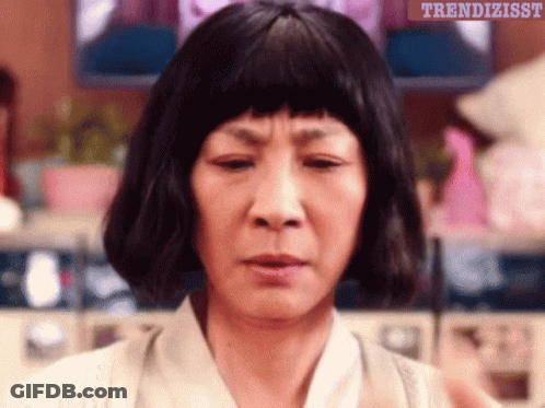 A Woman Wearing A Wig Is Making A Funny Face With The Words Trendizisst Written Above Her GIF