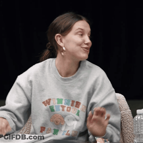 A Woman Wearing A Winnie The Pooh Sweatshirt GIF