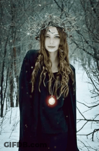 A Woman Wearing A Wreath Of Branches And A Necklace With A Coin On It GIF