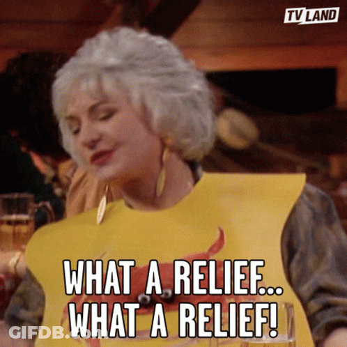 A Woman Wearing A Yellow Bib That Says What A Relief What A Relief GIF