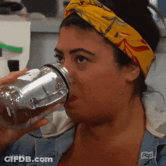 A Woman Wearing A Yellow Headband Is Drinking From A Clear Bottle .. GIF