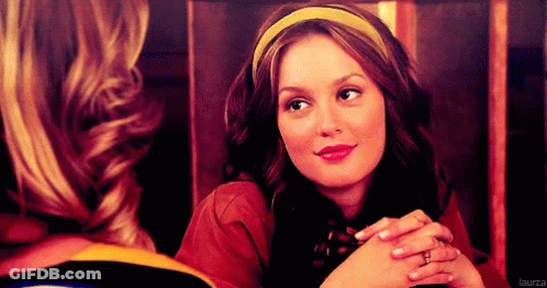 A Woman Wearing A Yellow Headband Is Smiling And Looking At Another Woman GIF