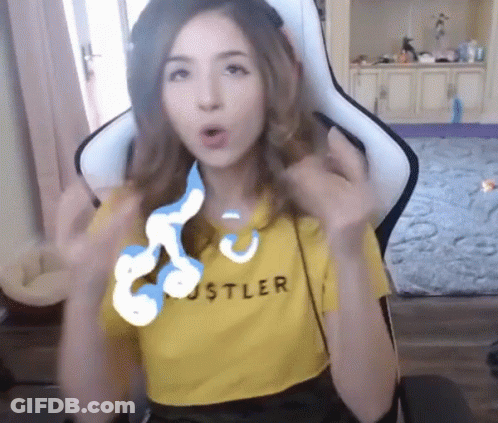 A Woman Wearing A Yellow Hustler Shirt Sitting In A Chair GIF