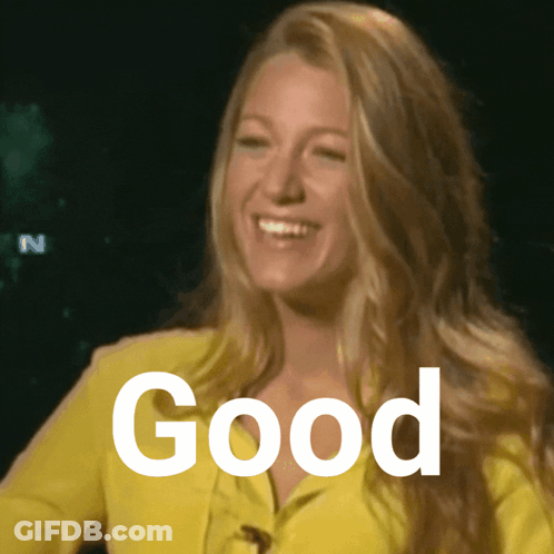 A Woman Wearing A Yellow Jacket Is Smiling And The Word Good Is Visible Behind Her GIF