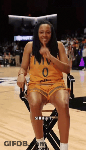 A Woman Wearing A Yellow Jersey With The Number 0 On It Sits In A Chair GIF