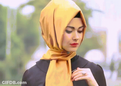 A Woman Wearing A Yellow Scarf And A Black Shirt GIF