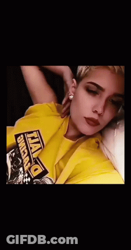A Woman Wearing A Yellow Shirt That Says Dewalt Is Blowing Purple Smoke Out Of Her Mouth GIF