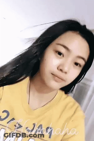 A Woman Wearing A Yellow Shirt That Says ' Hawaiiana ' On It GIF