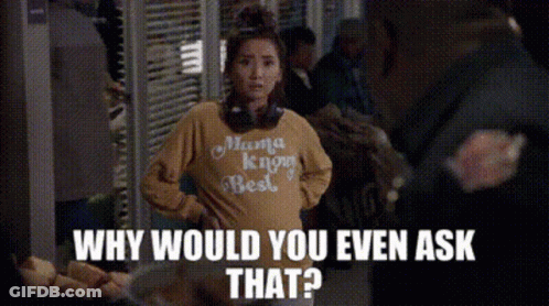 A Woman Wearing A Yellow Shirt That Says Mama Knows Best Is Standing In Front Of A Crowd Of People . GIF