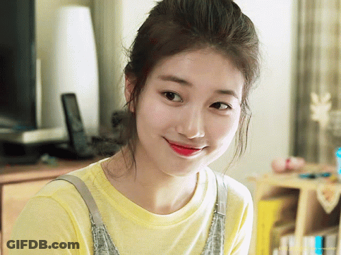 A Woman Wearing A Yellow T-Shirt And Overalls Smiles For The Camera GIF