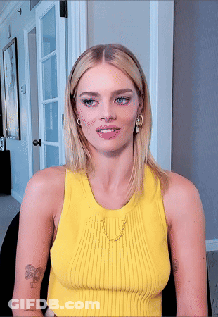 A Woman Wearing A Yellow Tank Top Has A Tattoo On Her Arm GIF