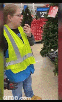 A Woman Wearing A Yellow Vest Is Talking On A Walkie Talkie In A Store .. GIF