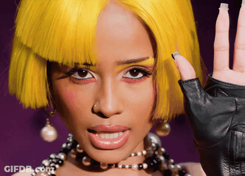 A Woman Wearing A Yellow Wig And A Black Glove GIF