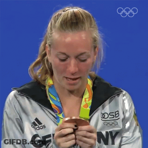 A Woman Wearing An Adidas Jacket Holds A Medal GIF