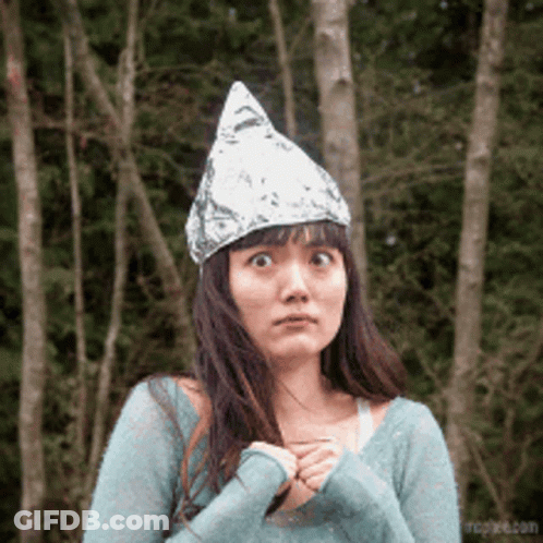 A Woman Wearing An Aluminum Foil Hat Looks Surprised GIF